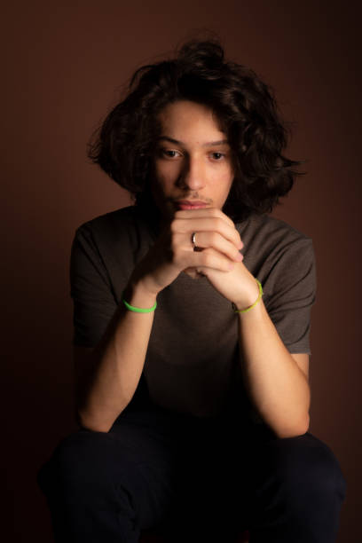 istock Handsome young man, sitting, with hand on face. 1464744685