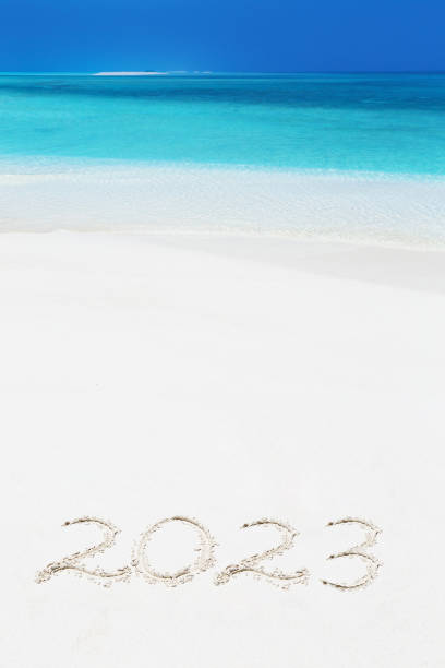 Handwritting inscription numbers 2023 on perfect tropical sandy beach stock photo