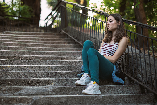 Woman sitting on stairs and feeling lonely