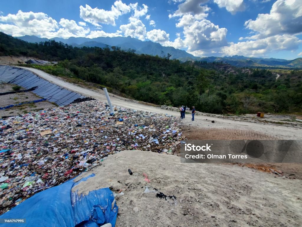 Proper landfill for waste Taken in the municipality of Gracias, Lempira in March 2022, it is a sanitary landfill where the garbage is handled properly, it is appreciated how the garbage and waste is buried with soil, which allows it to be handled properly, people supervise. Architecture Stock Photo