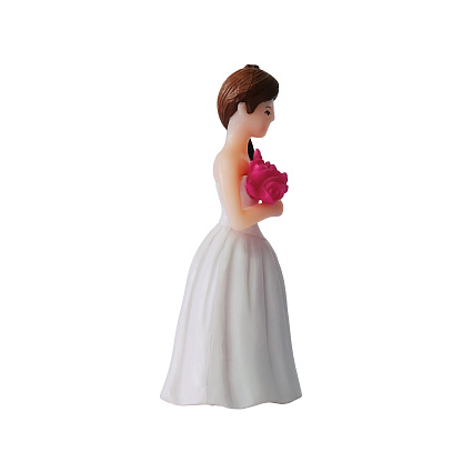 Wedding doll isolated on white background. Bride in white gown carrying pink bouquet