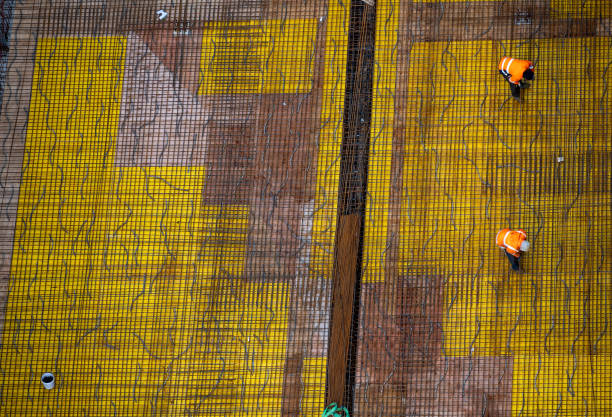 istock Top view of workers preparing a concrete foundation plate at a construction site. 1464752899