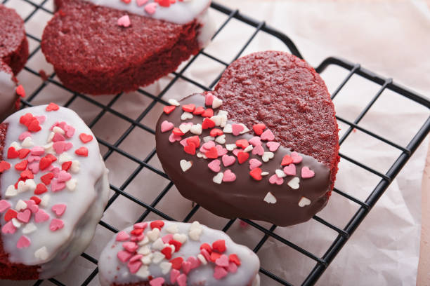 valentines day. red velvet or brownie cookies on heart shaped in chocolate icing on pink background. dessert idea for valentines, mothers or womens day. tasty homemade dessert cake for holiday. - valentine candy imagens e fotografias de stock
