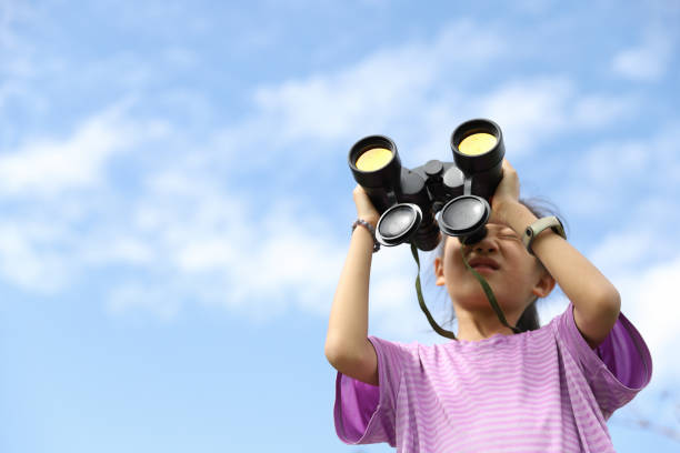istock girl looking at the scenery with a telescope. 1464753852