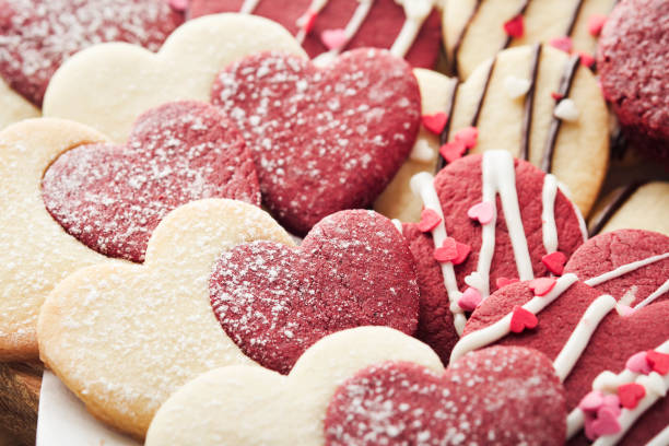 Valentines day cookies. Shortbread cookies inside sweet red heart with chocolate glaze on pink plate on grey background. Mothers day. Womans day. Sweet holidays baking. Valentines day card. Top view. galletas de san valentín. galletas de mantequilla dentro de corazón rojo dulce con glaseado de chocolate sobre plato rosa sobre fondo gris. día de la madre. día de la mujer. dulces vacaciones horneando. tarjeta de san valentín. vista superior.