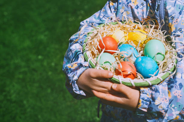 istock Colorful Easter eggs in basket. Kids hunt for eggs outdoors. 1464754680