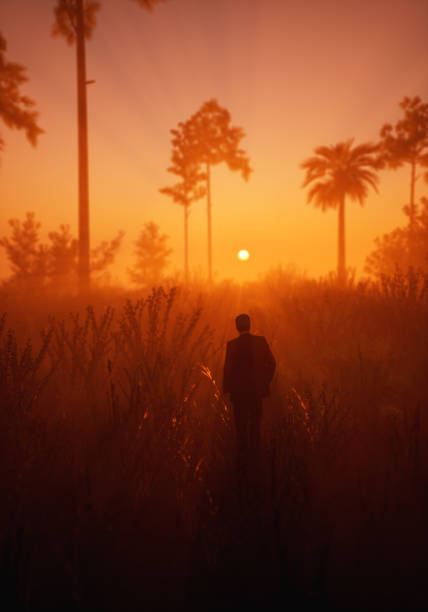 istock Silhouette of man in hazy tropical wilderness with palm trees during sunset. 3D render. 1464756444