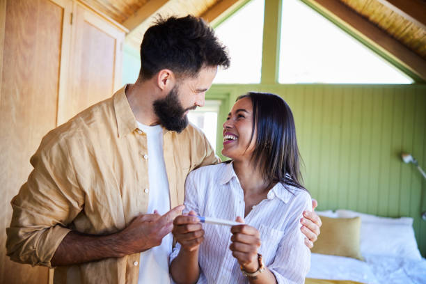 istock Ecstatic couple laughing after a positive home pregnancy test 1464756675