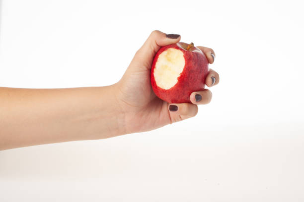 istock Hand holding bitten red apple isolated on white background 1464756950