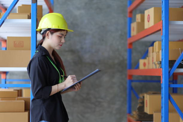 istock Female warehouse worker inspecting parcels on a shelf in a small warehouse. 1464758003