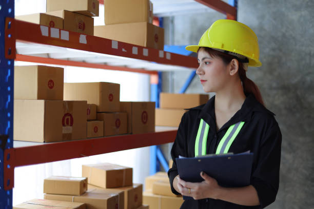 istock Female warehouse worker inspecting parcels on a shelf in a small warehouse. 1464758020