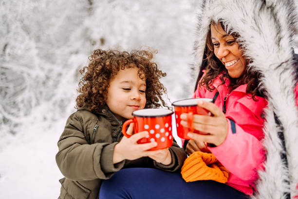 Mother and son drinking tea on a cold snowy day