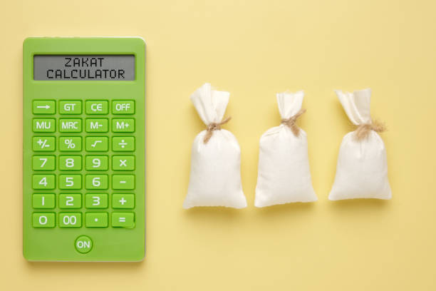 Zakat Calculator A picture of calculator written Zakat Calculator with 3 rice bags. How to calculate zakat concept. beg alms stock pictures, royalty-free photos & images