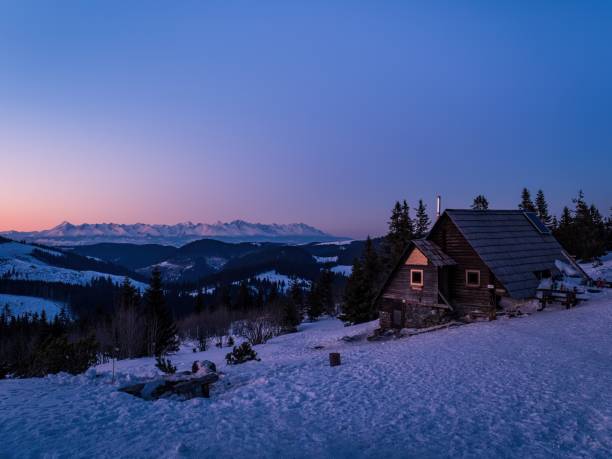 istock Mountain forest hut during purple ping orange sunset winter snow 1464762359