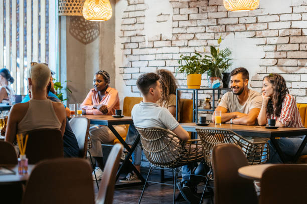 grupo de amigos relajándose en una cafetería - restaurante fotografías e imágenes de stock