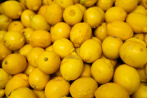Piles of fresh lemons. Full frame of fresh and juicy yellow lemons at farmer's market stall.