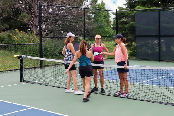 istock Four Female Pickleball Players Touch Paddles 1464763948