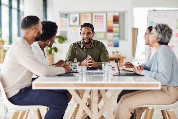 istock Business, black man and meeting with teamwork at table for planning, discussion and brainstorming ideas. Manager, collaboration and talking in startup, office and workshop analysis of company project 1464764017