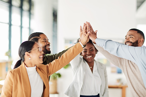 Teamwork, high five and community with business people in office for motivation, mission and support. Celebration, success and diversity with hands of employee for target, collaboration and goals
