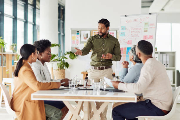 Business, black man or presentation with team, corporate training or conversation for sales growth or planning. African American male leader, employee or teamwork for charts, manager or collaboration negocios, hombre negro o presentación con equipo, capacitación corporativa o conversación para el crecimiento o la planificación de ventas. líder masculino afroamericano, empleado o trabajo en equipo para gráficos, gerente o colaboración