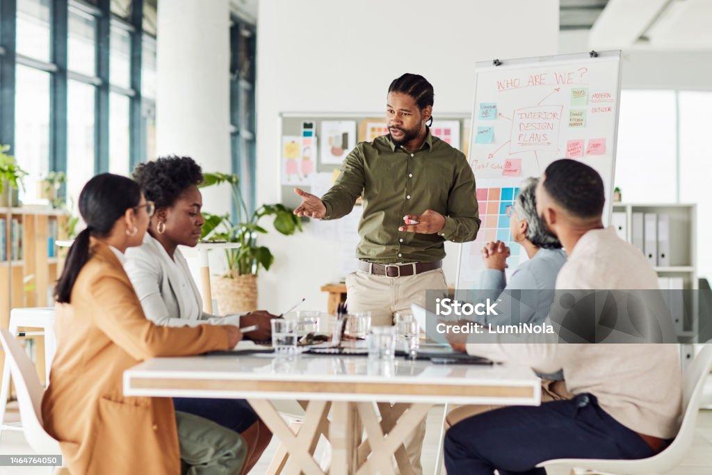 Business, black man or presentation with team, corporate training or conversation for sales growth or planning. African American male leader, employee or teamwork for charts, manager or collaboration Manager Stock Photo