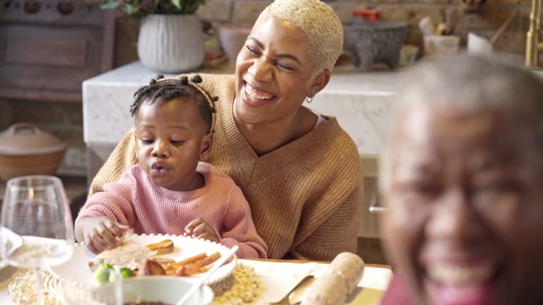 Black toddler eating Christmas lunch with her fingers