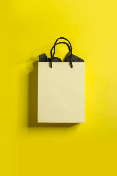 flat lay one yellow paper bag on yellow background. - sacos de presente imagens e fotografias de stock