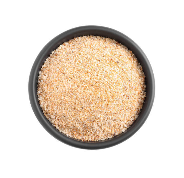 Fresh bread crumbs in bowl isolated on white, top view