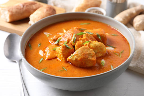 istock Bowl of delicious chicken curry on white table 1464770196