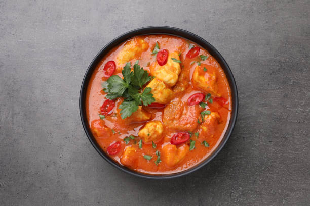 istock Bowl of delicious chicken curry on grey table, top view 1464770226