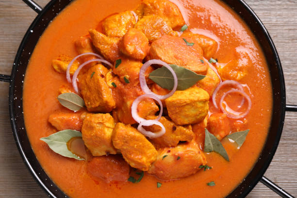istock Delicious chicken curry in pan on wooden table, top view 1464770251