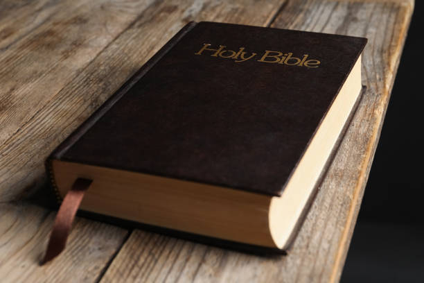 istock Bible with dark cover on wooden table. Christian religious book 1464771024