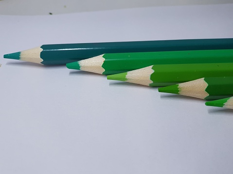 Five green pencils organized in increasing size order stock photo