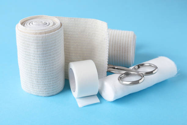 istock Medical bandage rolls, sticking plaster and scissors on light blue background 1464771744