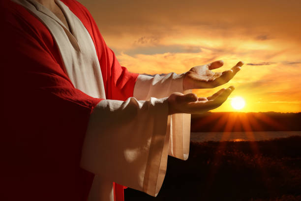 istock Jesus Christ reaching out his hands and praying at sunset 1464771806