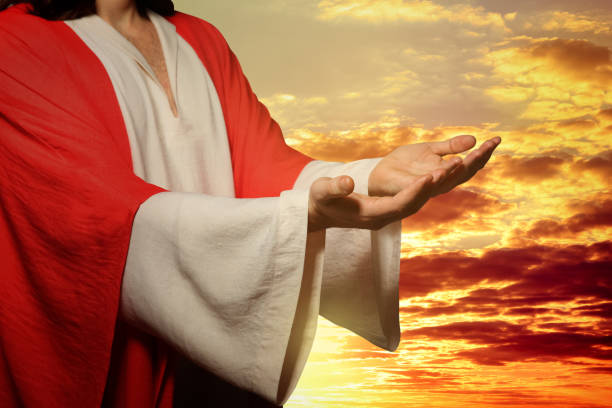 istock Jesus Christ reaching out his hands and praying at sunset 1464772030