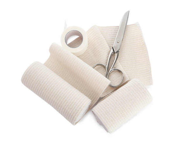 istock Medical bandage rolls, sticking plaster and scissors on white background, top view 1464772442