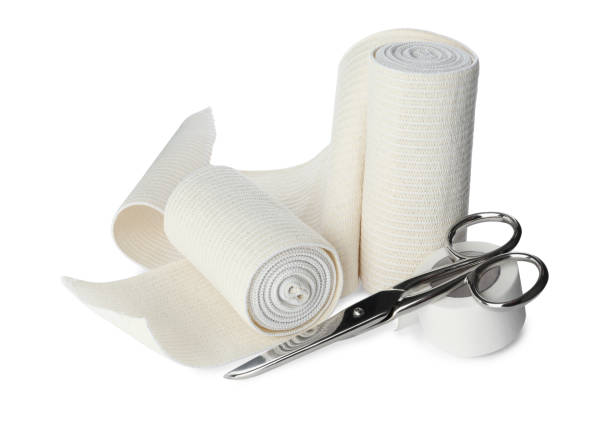 istock Medical bandage rolls, sticking plaster and scissors on white background 1464772446