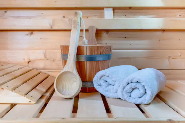 Detail from buckets and white towels in a sauna, wellness accessories.