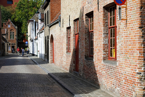 Bruges, Belgium - September 12, 2022: Narrow cobbled streets often with small houses along them are located in the old part of the city, well known for its preserved old architecture