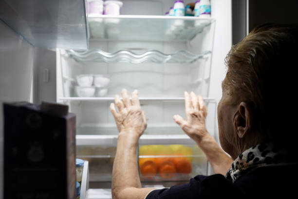 istock lady looking inside the fridge in the kitchen. loneliness in old age 1464773846