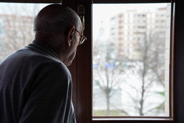 istock caucasian senior looking at the window. loneliness in elderly 1464773918