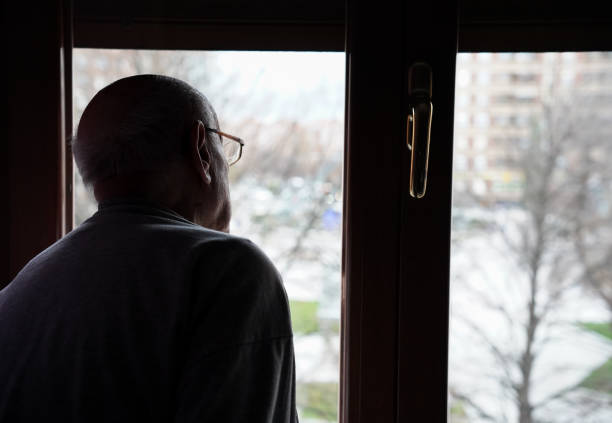 istock caucasian senior looking at the window. loneliness in elderly 1464773935