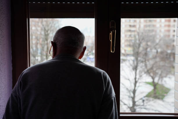 istock caucasian elder man looking at the window. loneliness in elderly 1464773947