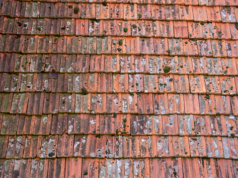 Old roof scratched red clay tile plates texture top view