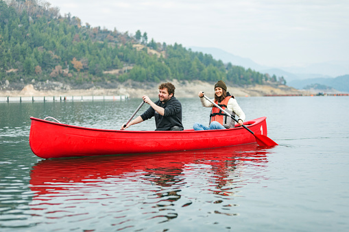 Young adult couple canoeing at the lake