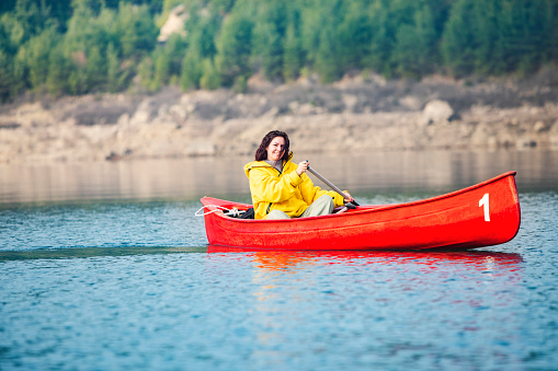 Young adult woman canoeing at the lake