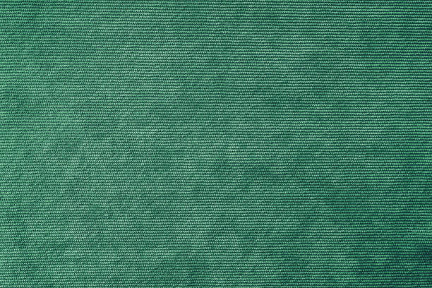 Green velveteen upholstery fabric texture background.