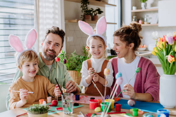istock Happy family with little kids decorating easter eggs. 1464781731