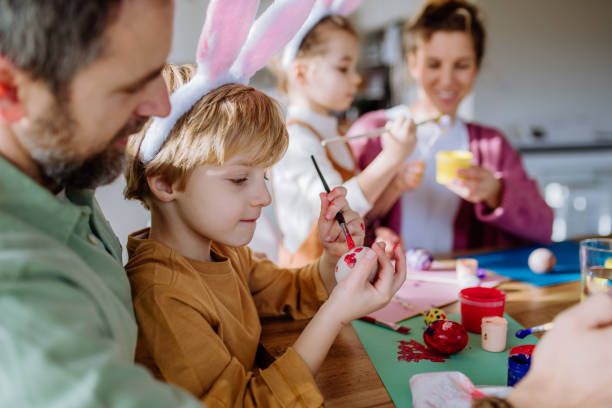 istock Happy family with little kids decorating easter eggs. 1464781746